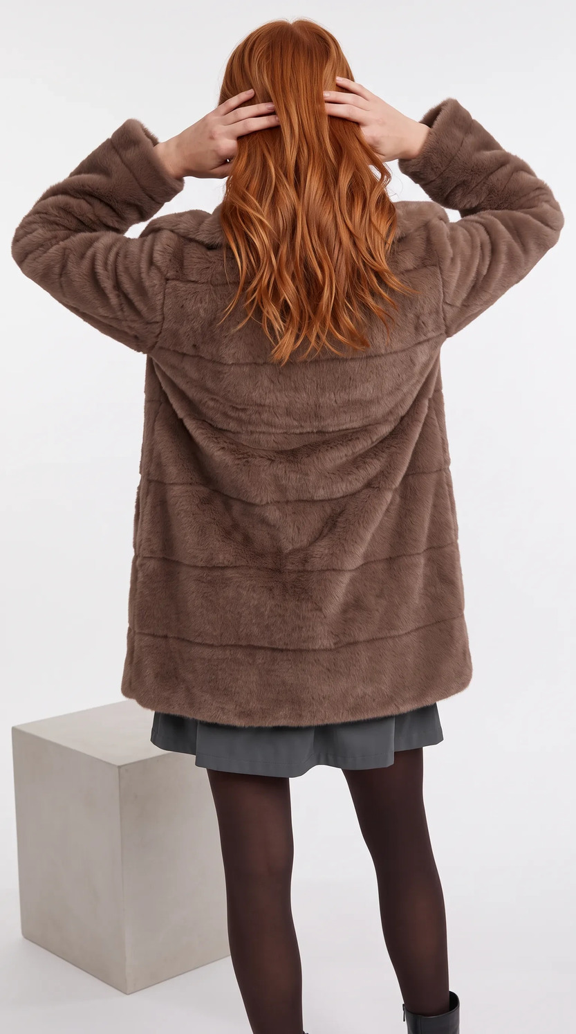 Studio frame of the coat from the back, hands in the model’s hair